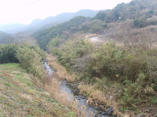  댐이 건설되면 오른쪽 산기슭 상단부에 보이는 흰색 작은 점의 위치까지 물이 차오르게 된다. 이시키강 댐 건설예정(수몰예정)지.  