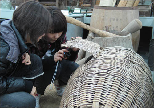 슬비와 예슬이가 옛 닭장을 살펴보며 카메라에 담고 있다.