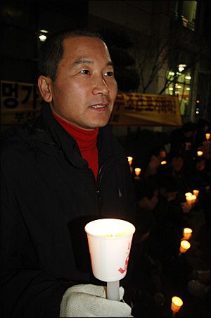 화덕헌(46)씨가 18일 저녁 부산 해운대 홈플러스 센텀점 앞에서 열린 중소상인연합회의 'SSM 입점 반대' 촛불문화제에 참석해 촛불을 들었다.