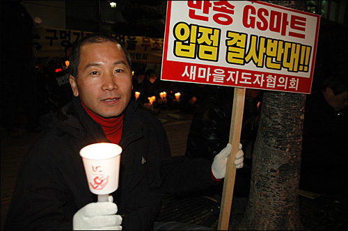 화덕헌(46)씨가 18일 저녁 부산 해운대 홈플러스 센텀점 앞에서 열린 중소상인연합회의 'SSM 입점 반대' 촛불문화제에 참석해 촛불을 들었다.