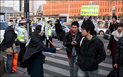  전쟁없는세상 무기제로팀 회원들이 '집속탄금지협약' 가입을 촉구하는 '신호등 캠페인'을 벌이고 있다.