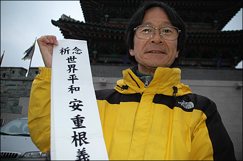 27일 진주성을 찾은 일본인 데라시타 다케시씨가 '세계평화 안중근 의사 추모 여행'이라고 쓴 어깨띠를 들어 보이고 있다.