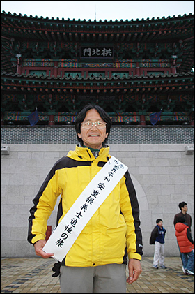 27일 진주성을 찾은 일본인 데라시타 다케시씨가 '세계평화 안중근 의사 추모 여행'이라고 쓴 어깨띠를 두르고 진주성 공북문 앞에 서 있다.