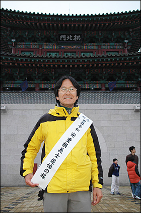  27일 진주성을 찾은 일본인 데라시타 다케시씨가 '세계평화 안중근 의사 추모 여행'이라고 쓴 어깨띠를 두르고 진주성 공북문 앞에 서 있다.