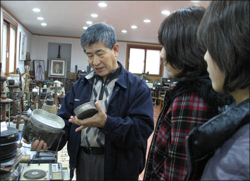 와보랑께박물관의 김성우 관장이 옛 생활용품을 들고 거기에 얽힌 얘기를 들려주고 있다.