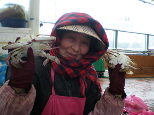 생선장수 김숙자 할머니가 꽃게를 양손에 들어 보이며 환한 표정을 짓는다.