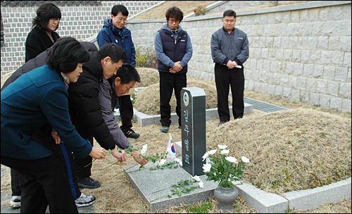  김천욱 민주노총 경남본부장과 이종엽 창원시의원 등이 3.15의거 50주년을 하루 앞둔 14일 오전 국립3.15민주묘지에 있는 김주열 열사의 묘소를 찾아 헌화하고 있다.