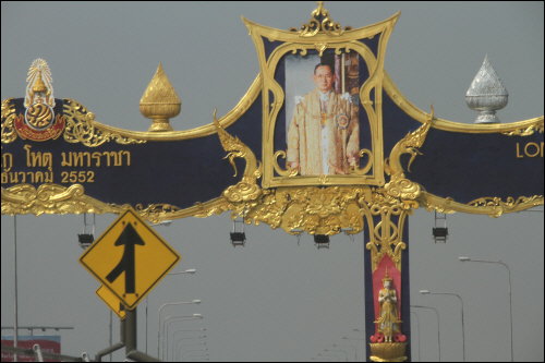 공항에서 방콕시내로 들어가는 고속화도로에 세워진 황금테두리의 장식으로 국왕의 만수무강을 기원하는 'LONG LIVE THE KING'아치와 국왕의 초상 사진

