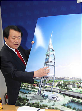 자유선진당 염홍철 대전시장 예비후보가 엑스포과학공원 내에 건축할 친환경 첨단복합건물인 '인터내셔널 사이언스 타워' 조감도를 내보이며 설명하고 있다.