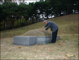 필자가 뤼순감옥 묘지에서 채취해온 흙을 안중근 장군 가묘에 헌토하고 있다.