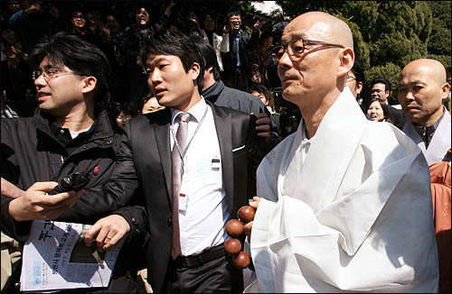 봉은사 주지 명진스님이 28일 오전 서울 삼성동 봉은사에서 법회를 마친 뒤 신도들과 취재진에 둘러싸인 채 법왕루를 나서고 있다. 2010.3.28