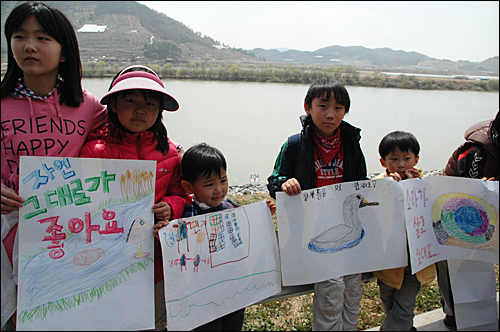 '4대강사업 중단 수륙대재'가 28일 오후 함안보 아래 백사장에서 열렸는데, 어린이들이 4대강사업에 반대하는 그림을 그려와 낙동강가에 서서 펼쳐 보이고 있다.