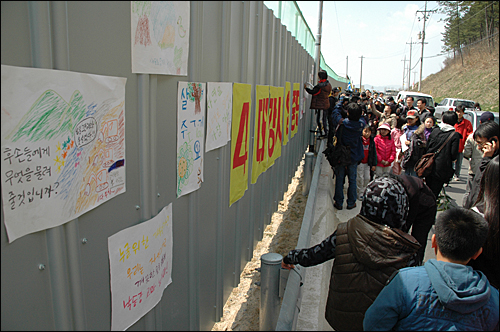 '4대강사업 중단 수륙대재'가 28일 오후 함안보 아래 백사장에서 열렸는데, 어린이들이 '4대강사업 반대'하는 내용의 그림을 그려와 함안보 공사장 가림막에 붙이고 있다.