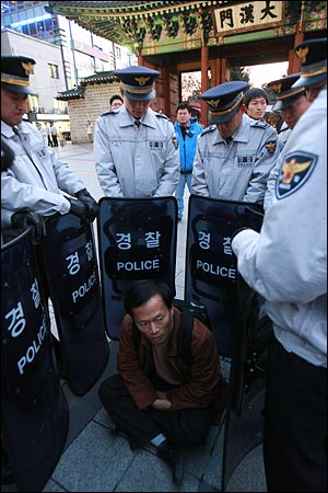 덕수궁앞을 원천봉쇄한 경찰들이 최승국 녹색연합 사무처장을 에워싸고 있다.