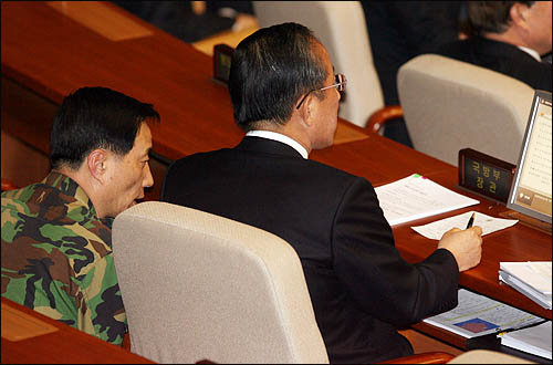 2일 오후 국회 긴급현안질의에 출석한 김태영 국방부장관이 군 관계자로부터 보고를 받고 있다.