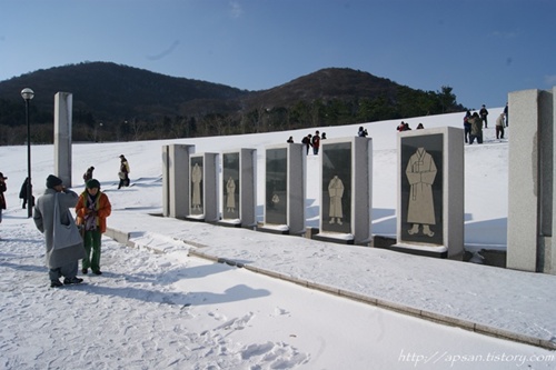 제주4.3 당시 민간인들의 죽음의 이미지와 전래의 수의를 모티브로 한 조형물이다. 견학팀이 작품을 자세히 둘러보고 있다. 
