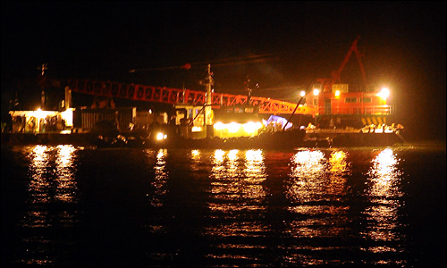 천안함 침몰 11일째인 5일 저녁 기상 악화로 작업이 중단된 백령도 앞바다에서 인양준비중인 대형 해상크레인이 불을 밝히고 있다.