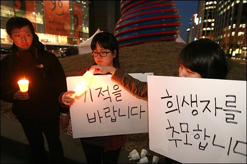 6일 저녁 서울 청계광장에서 한국대학생문화연대 소속 대학생 4명이 '천안함' 침몰사건 희생자와 실종자를 위한 촛불집회를 열고 있다.