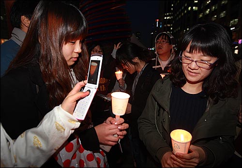 7일 저녁 서울 청계광장에서 열린 천안함 침몰 희생자 추모 촛불집회에 참가한 학생이 경찰에게 촛불을 빼앗길 경우 대체하기 위해 휴대폰 카메라로 촛불을 찍고 있다.    