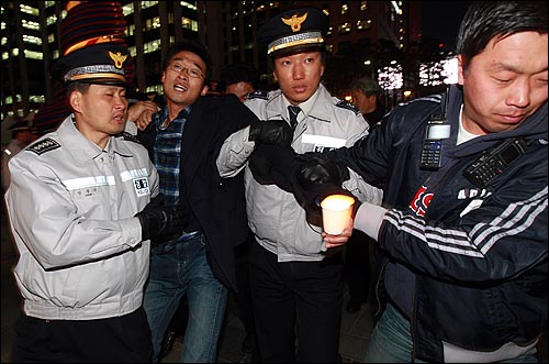 경찰들이 7일 저녁 서울 청계광장에서 열린 천안함 침몰 희생자 추모 촛불집회가 추모형식을 빌린 미신고 불법집회라며 참가한 학생들을 강제연행하고 있다. 