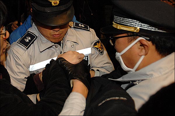 지난 4월1일 해군 초계함 '천안함' 실종자 46명의 무사귀환과 진상규명을 촉구하는 촛불행사장에서 경찰관들이 초와 종이컵을 빼앗기 위해 달려들고 있다.