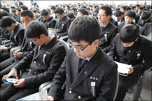 11일 마산중앙부두에서 김주열 열사 범국민장이 열렸는데, 후배들인 마산 용마고 학생들이 가슴에 검정색 리븐을 달고 참석해 앉아 있다.