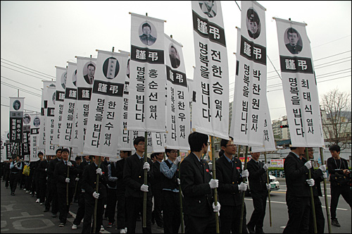 김주열 열사 범국민장이 11일 마산에서 열렸다. 사진은 운구행렬 때 3.15와 4.19 때 희생된 민주영령 186명의 얼굴 사진을 넣은 만장을 학생들이 들고 가는 모습.