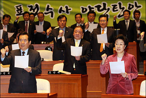 뇌물수수 혐의로 기소됐다 1심에서 무죄판결을 받은 한명숙 전 국무총리가 12일 오전 민주당 의원총회에 참석해 정세균 대표 등과 함께 '정치검찰' 규탄 구호를 외치고 있다.