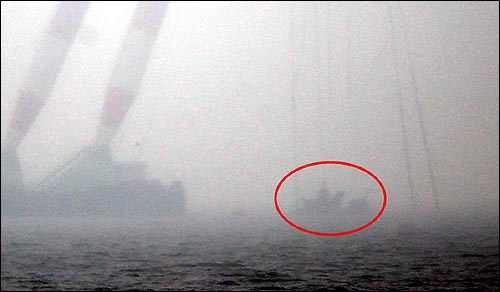 해군 초계함 '천안함' 침몰 18일째인 12일 오후 백령도 연화리 함미 침몰해역에서 작업중이던 대형크레인이 인양한 함미를 인양해 백령도 인근 연안으로 이동하고 있다.