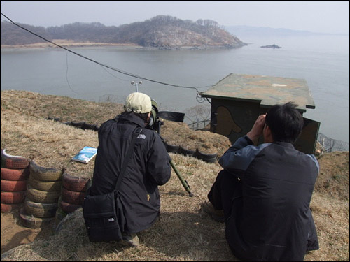 필드스코프와 쌍안경으로 유도의 새들을 조사하는 손성희 연구원(왼쪽)과 박건석 선생님(오른쪽)