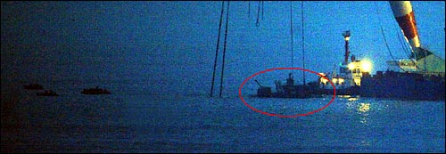 해군 초계함 '천안함' 침몰 18일째인 12일 저녁 함미 침몰해역에서 작업중이던 대형크레인이 함미부분에 쇠사슬 2개 결색을 완료한뒤 수심이 낮은곳에서 정박해 있다.