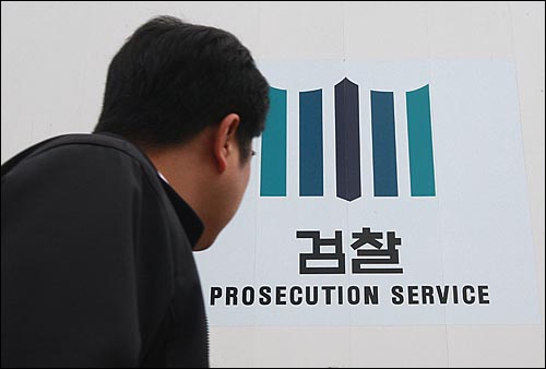  한 건설업체 대표가 수십명의 검사들에게 금품, 향응을 접대했다는 주장이 제기돼 파문이 커지고 있는 가운데 21일 오전 서울 서초동 대검찰청 앞에서 한 시민이 검찰 로고를 보며 지나가고 있다.