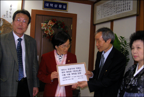  20일 한글단체 관계자들이 정경자(가운데) 대전유성구 부구청장에게 외래어가 포함된 동 이름 지정을 중단해 달라고 요구하는 밝힘 글을 전달하고 있다. 