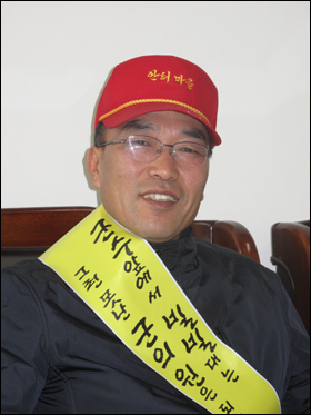 오한흥 옥천군의원 예비후보자는 평상복에 빨간 모자를 쓰고 노란 어깨띠를 두른 채 선거운동을 한다.  