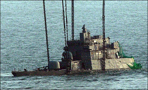 해군 초계함 '천안함' 침몰 28일째인 23일 오후 백령도 장촌포 앞 해역에서 인양을 위해 함체 바로세우기 작업이 완료된 '천안함' 함수가 수면 위로 모습을 드러내고 있다.