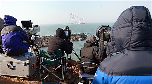  천안함 침몰 29일째인 24일 오전 백령도 장촌포 함수 인양작업 해역에서 취재진들이 함수 인양 작업을 취재하기 위해 함수 부분을 주시하고 있다.