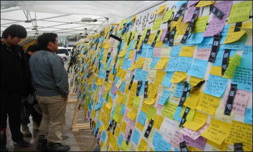 분향소 옆에 차려진 천안함 희생자에게 보내는 추모의 메시지들을 사람들이 보고있다. 
