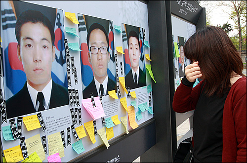 천안함 희생자들의 영결식이 열린 지난 2010년 4월 29일 오전 서울 시청 앞 서울광장에 마련된 '천안함 추모 사진전'을 찾은 한 시민이 사진과 추모 글귀를 보며 눈물을 흘리고 있다.