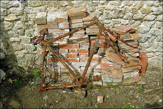 앙상한 형체만 남은 옛날 자전거가 프랑소와의 안뜰에서 쉬고 있다.