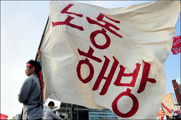 120주년 세계노동절 기념식에서 한 참가자가 노동해방 깃발을 들고 있다.