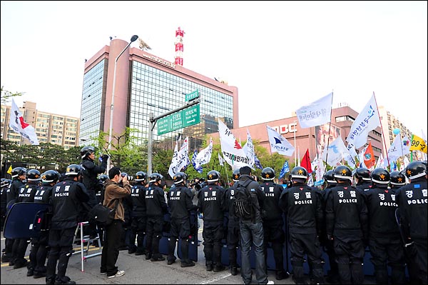 노동절 기념행사를 마친 참가자들이 경찰에 둘러싸인채 파업을 벌이고 있는 MBC 방송국앞에서 마무리 집회를 하고 있다.