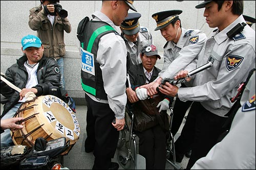 경찰들이 달려와 '우산'도 뺏어가고 있다.