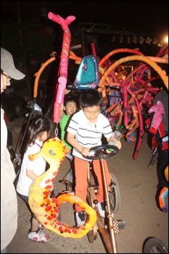 아이들이 삼덕동 마고재 앞에 놓여진 희망자전거를 타보고 있는 모습.