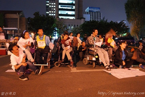 장애인들이 노래를 함께 따라 부르면서 촛불문화제에 참여하고 있다 