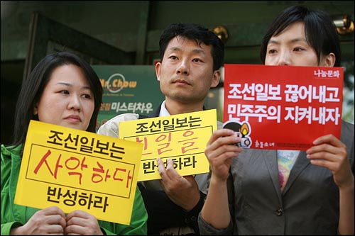 기자회견 참석자들이 '조선일보 0000 반성하라'는 손피켓에 다양한 주장을 써서 들고 있다.