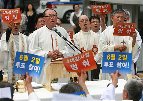 천주교정의구현사제단은 17일 오후 서울 명동성당 들머리에서 '4대강 사업 중단 촉구 전국사제단 단식기도회'를 열고 이날부터 단식에 돌입했다. 기도회 참석자들이 '4대강 사업 멈춰' '6월 2일 투표 참여'가 적힌 손피켓을 들고 있다.