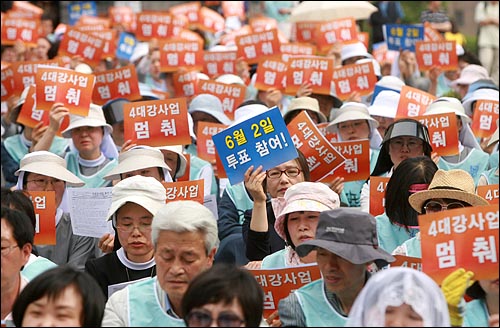 기도회 참석자들이 '4대강 사업 멈춰' '6월 2일 투표 참여'가 적힌 손피켓을 들고 있다.