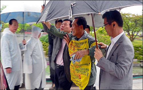  5월항쟁 진상규명을 촉구하며 3시간 동안 마라톤을 벌인 대전의 신현규씨(64)를 경찰이 연행하고 있다.