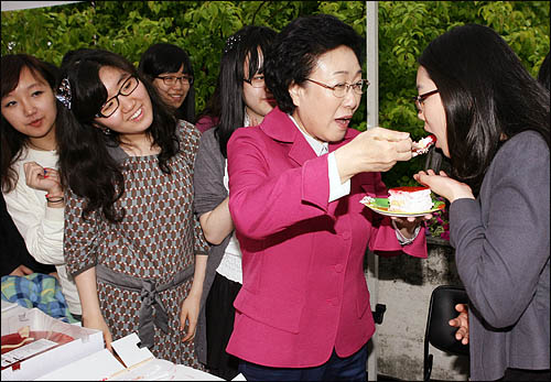 한명숙 민주당 서울시장 후보가 18일 오후 모교인 이화여대를 방문, 캠퍼스내의 동아리 장터에 들러 케이크를 맛본 후 학생들에게도 권하고 있다.