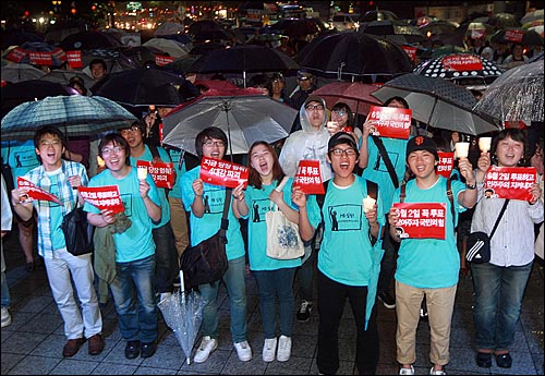 18일 저녁 서울 종로구 보신각 앞에서 열린 '5.18 30주년 기념 집회'와 '반성촛불페스티벌'에 참가한 시민들이 6.2지방선의 투표 참여를 독려하는 손피켓을 든 채 공연을 즐기고 있다.
